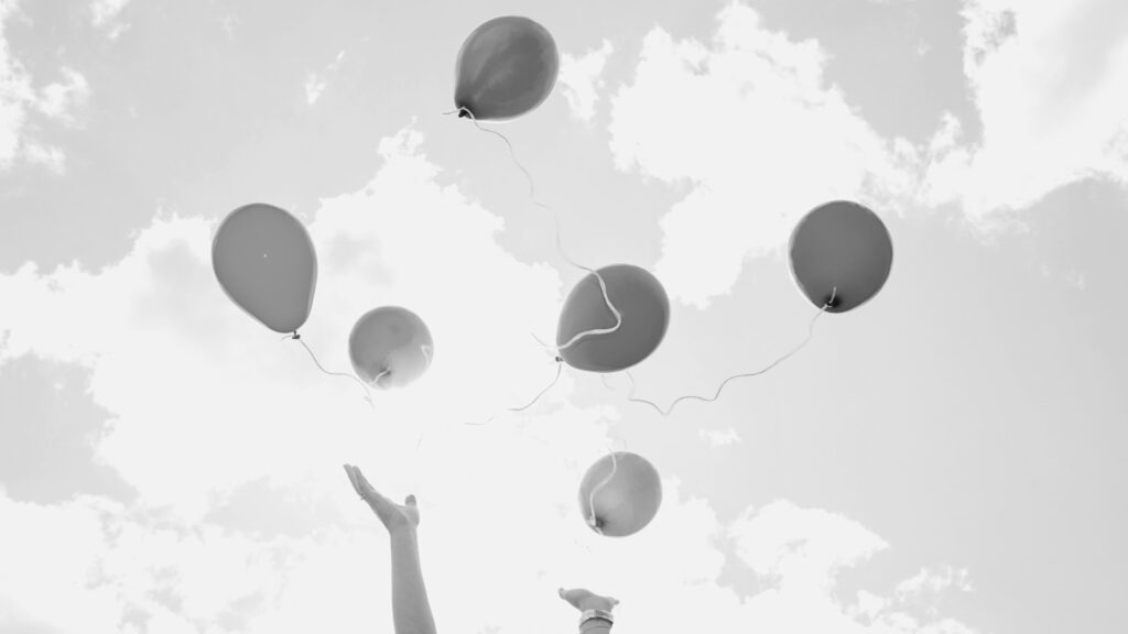 Ballonger och händer mot himlen